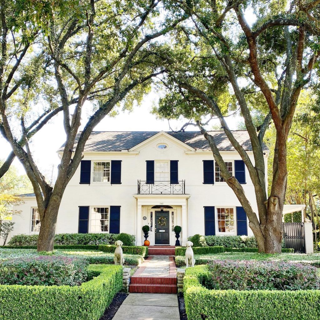 Colonial style home with green lawn and trees. photo credit @ charmingaustintexas
