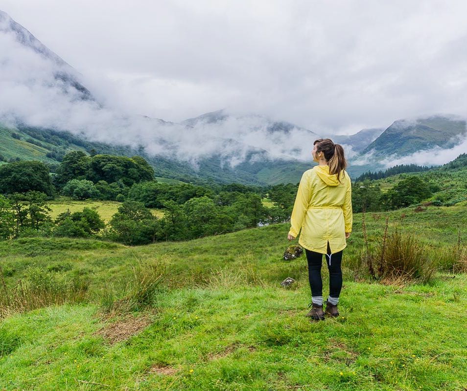 Girl in yellow jacket staring at mountains