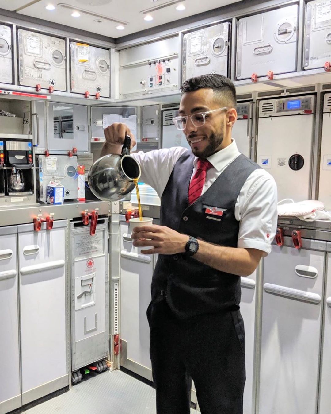 Male flight attendant with Air Canada pouring coffee. Photo by Instagram user @globetrotter95_