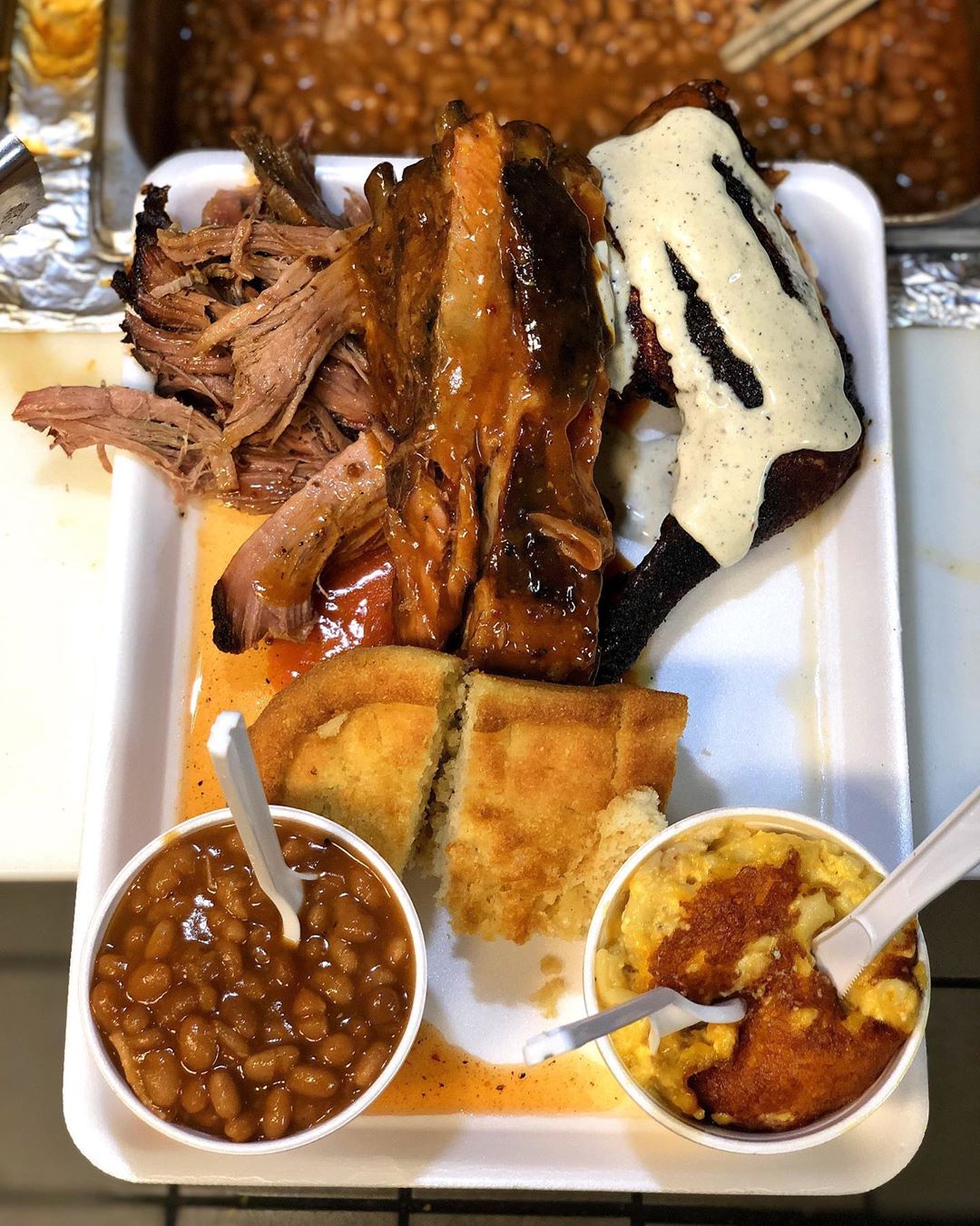 Plate of pulled pork and baked beans from Saws BBQ. Photo by Instagram user @saws_bbq