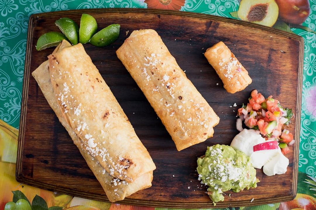 Wooden tray of chimichangas. Photo by Instagram user @elcharro.cafe