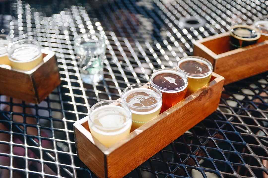 Wooden box that has samples of beer in it. Photo by Instagram user @avondalebrewing