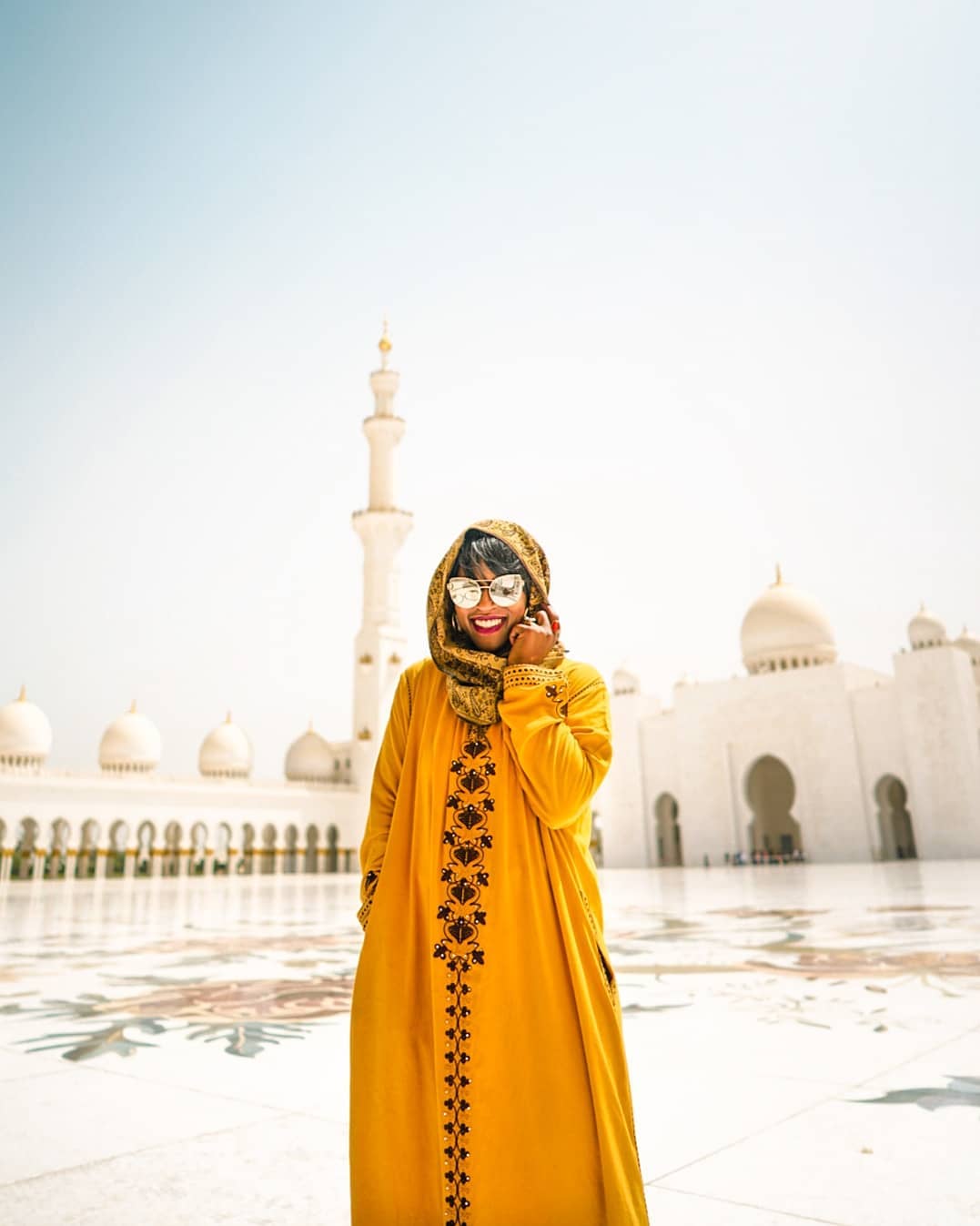 Girl in yellow sari in front of a mosque. Photo by Instagram user @glographics