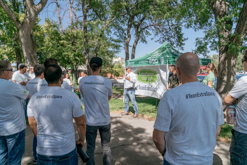 Group of Extra Space Storage employees stand together to listen to CEO Joe Margolis talk