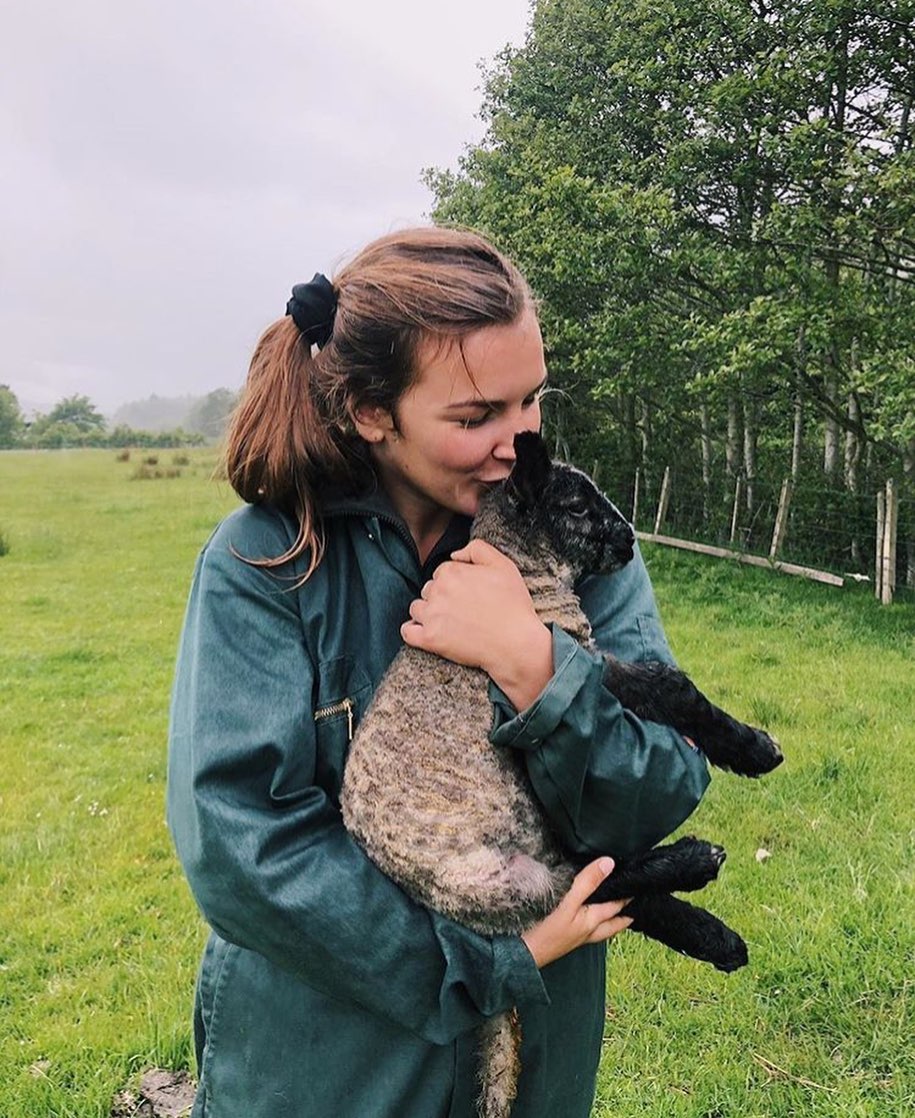 Young woman holding a black-faced lamb. Photo by Instagram user @johannaa.mariiee