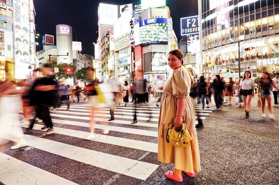 Girl standing in the middle of crosswalk in Tokyo. Photo by Instagram user @fracosma