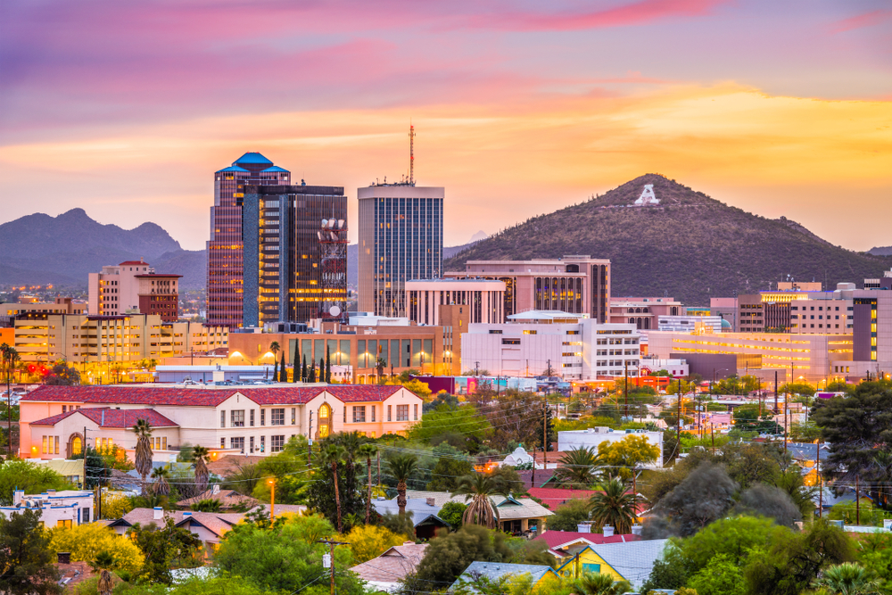 Skyline of tall buildings and a mountain during sunset in Tucson.