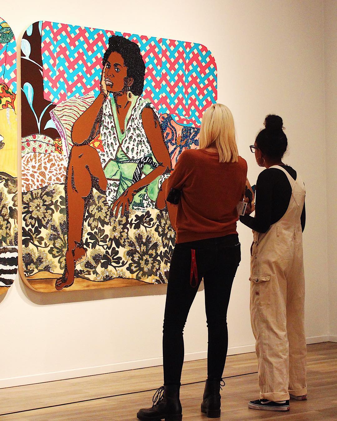 Two women looking at a piece of art of a woman. Photo by Instagram user @tucsonmuseumofart