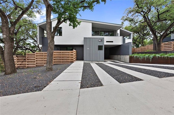 Two-story modern grey house with gravel driveway. Photo by Instagram user @nissiatxrealtor