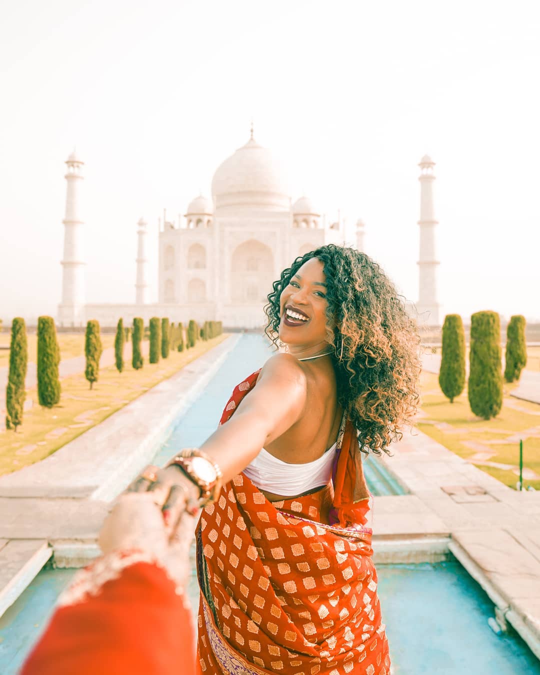 Influencer holding hands with man in front of Taj Mahal. Photo by Instagram user @glographics