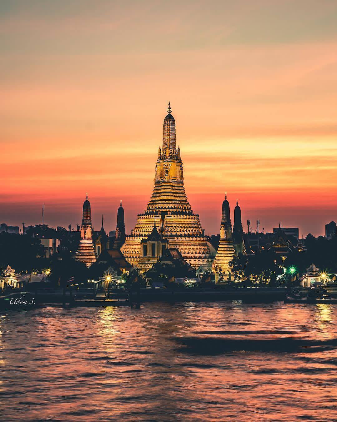 Red sunset behind a large temple in Bangkok, Thailand. Photo by Instagram user @we.thailand