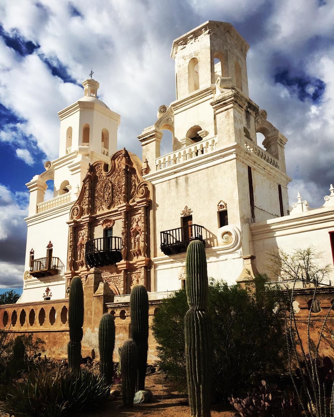 White Mission San Xavier del Bac with cacti in front of it. Photo by Instagram user @morgan_lorraine_