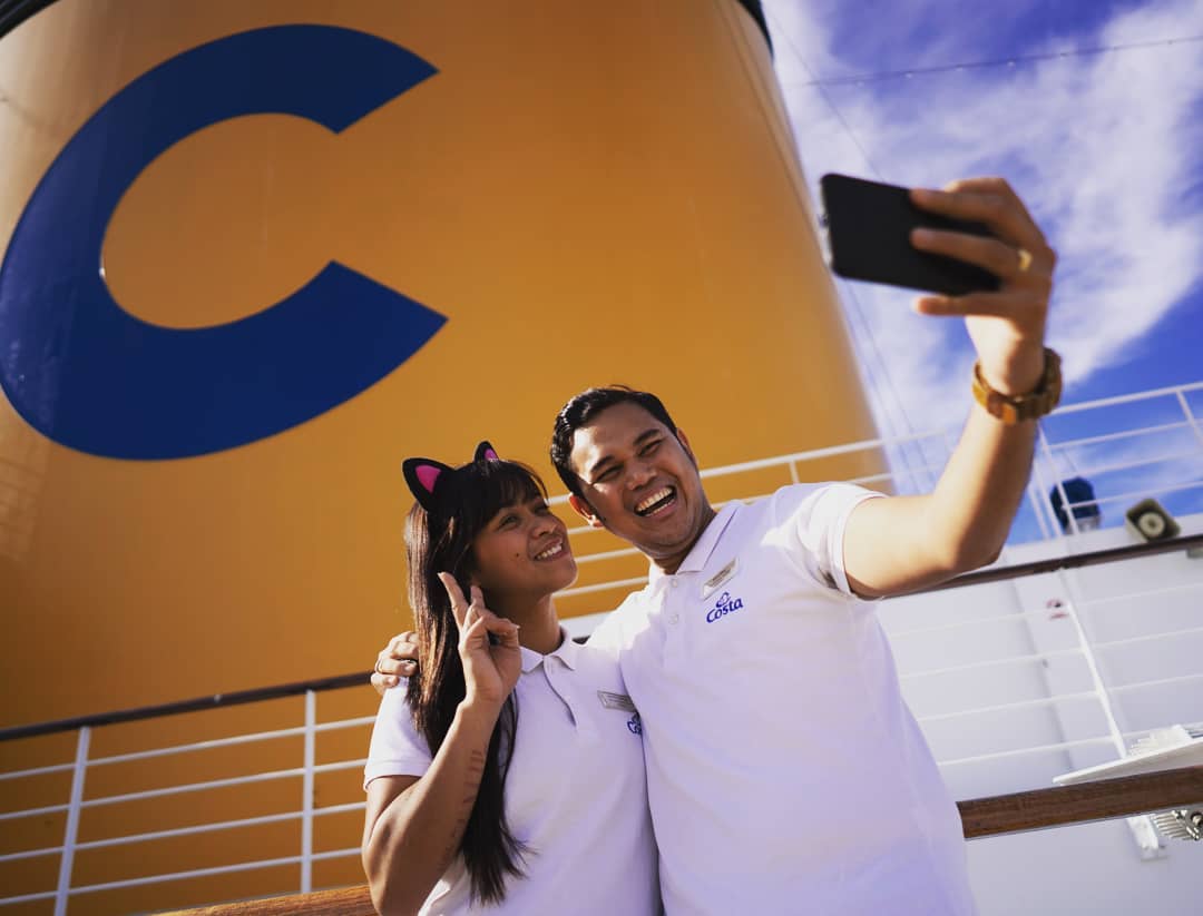 Cruise ship workers posing for selfie. Photo by Instagram user @costacrociercareers