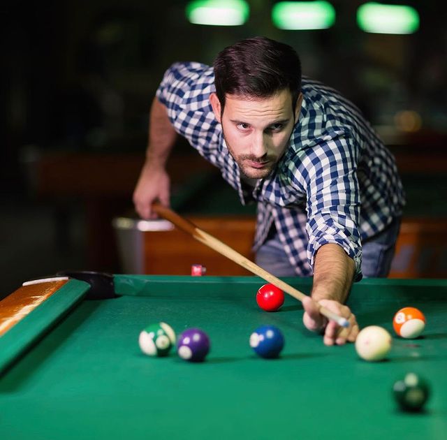 A man lining up his next shot on the pool table. @cowboyscs