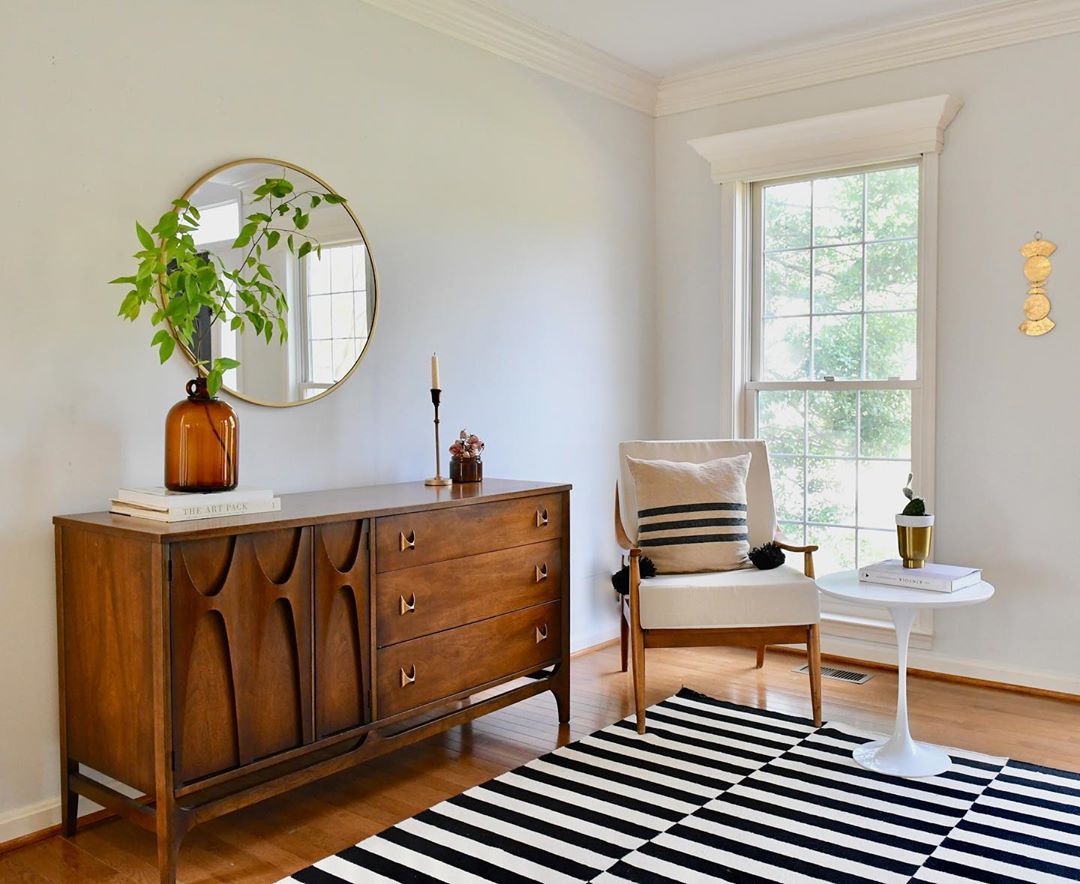 White room with credenza and striped carpet. Photo by Instagram user @zigzagstudiodesign