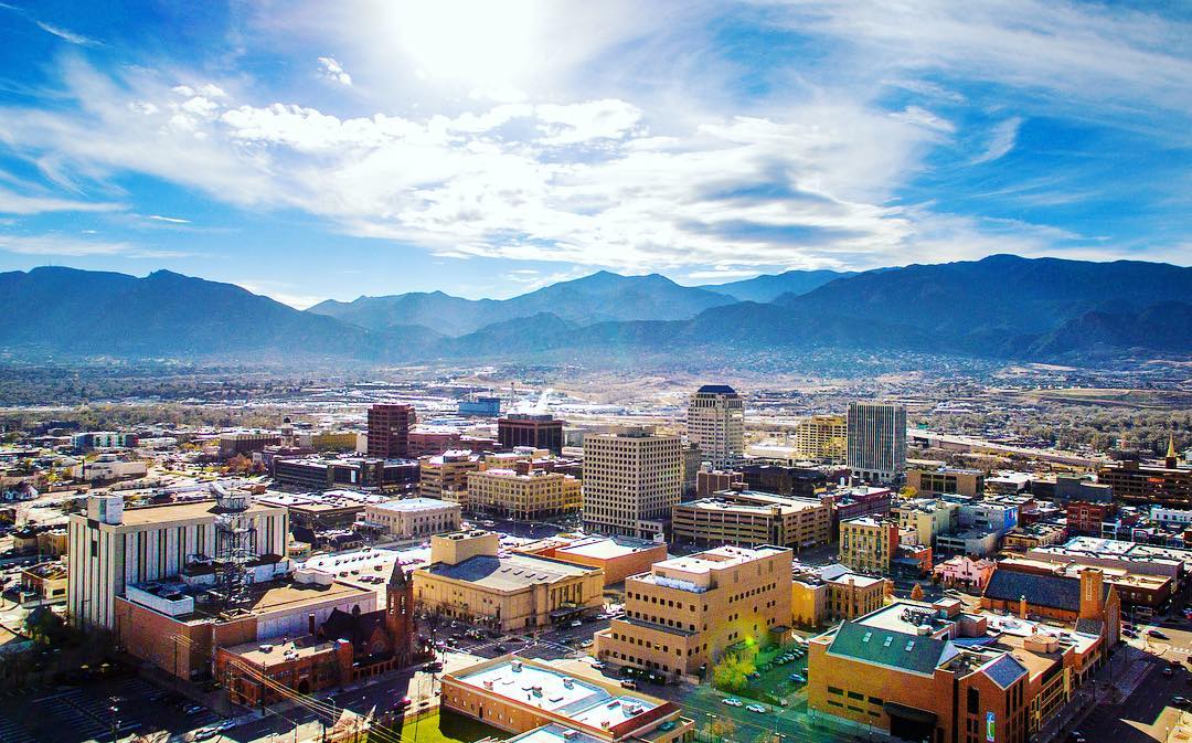 Skyline of tall buildings and businesses in Colorado Springs. Photo by Instagram user @properfilms