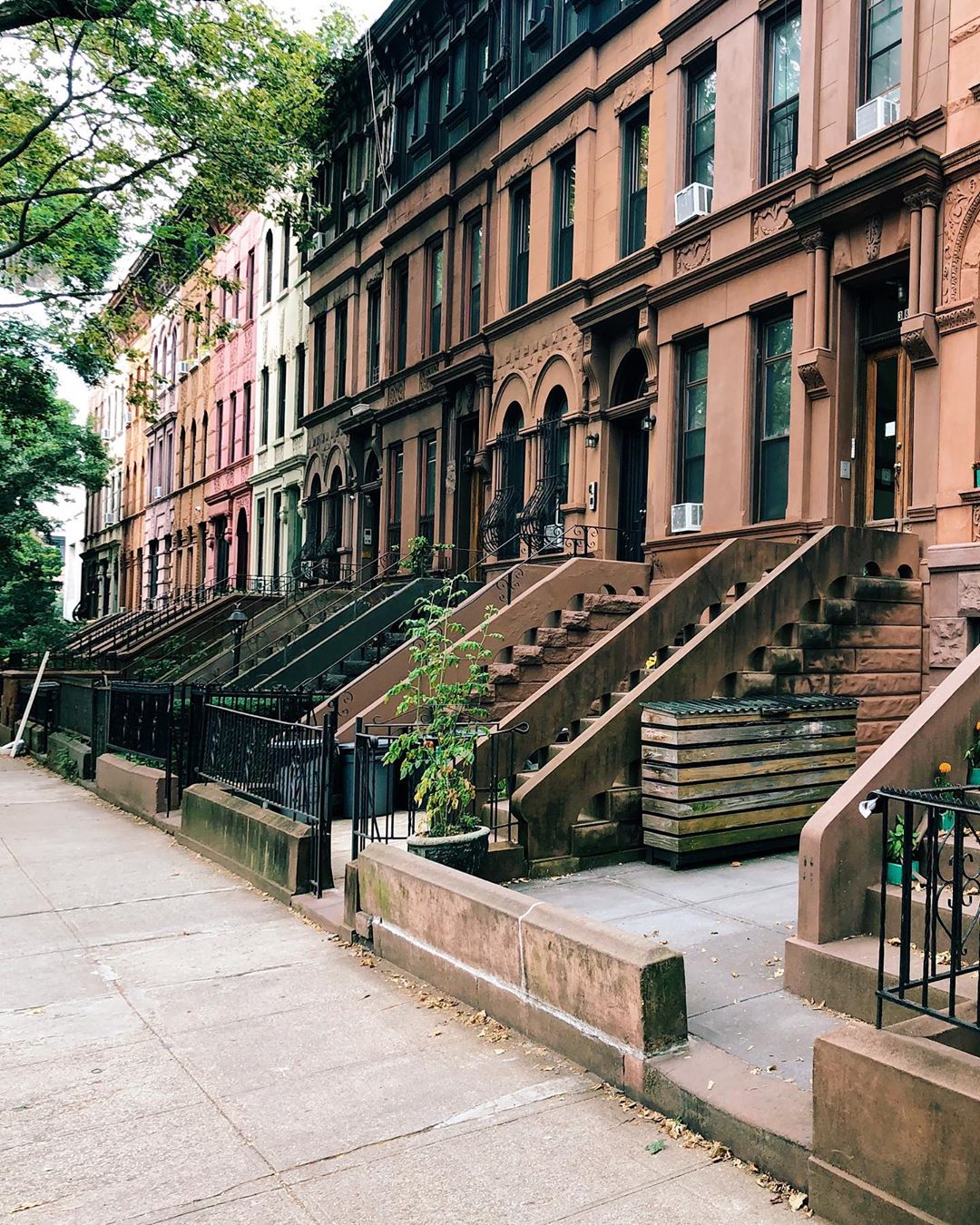 Brown, pink, and green rowhouses. Photo by Instagram user @andreabakacs