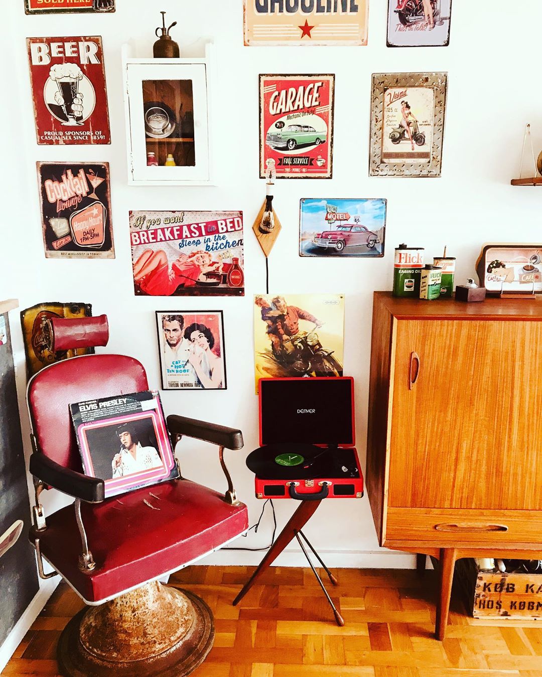Room with tin signs on wall and red chair. Photo by Instagram user @vampeva