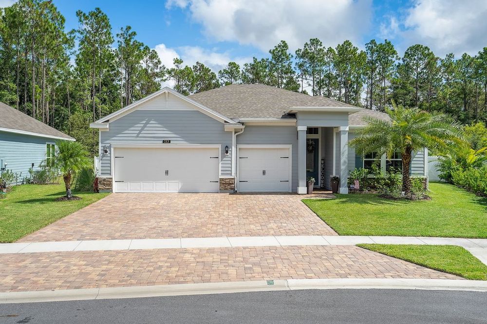 Blue ranch home with White garage doors. Photo by Instagram user @illuminatedimagesllc