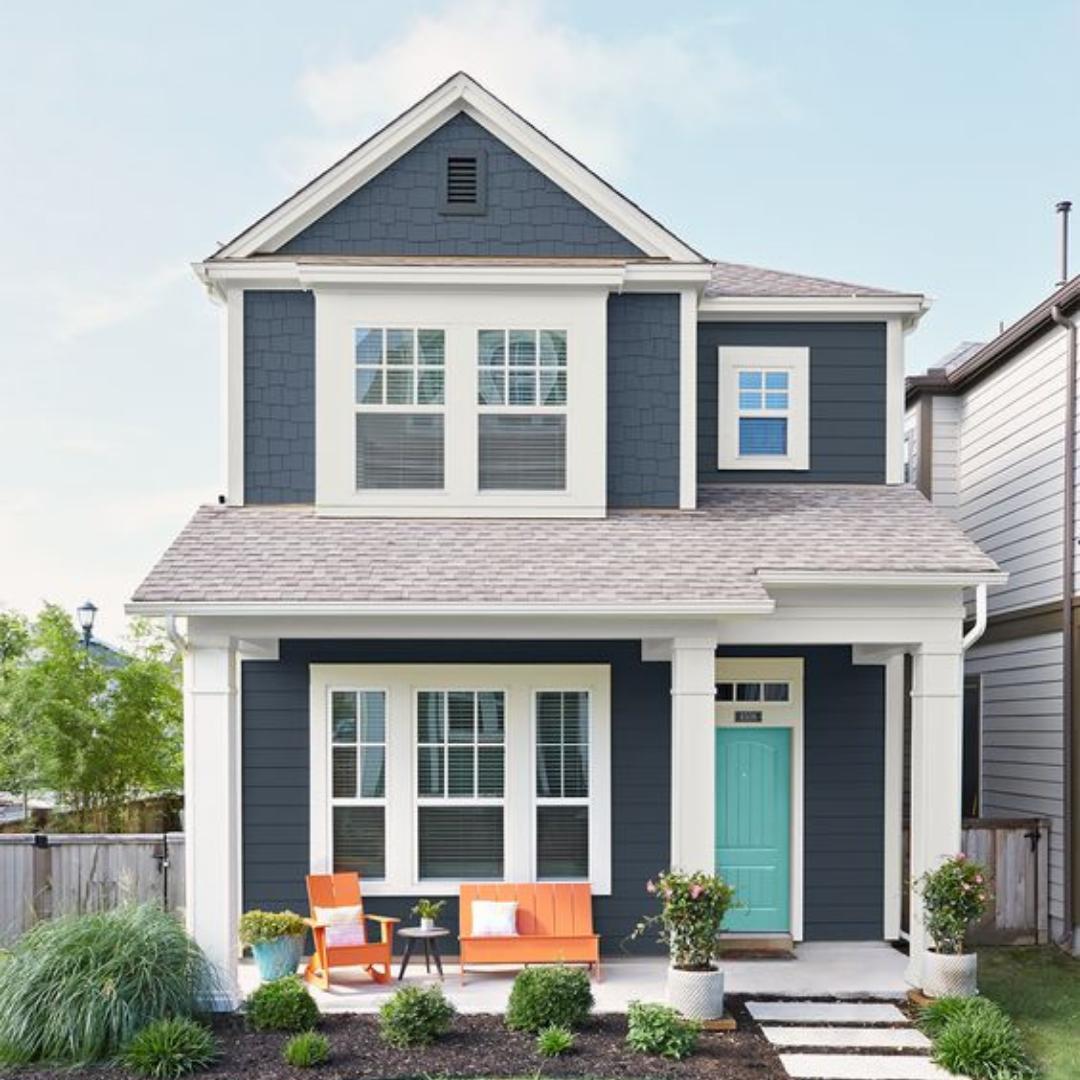 Navy Blue Two Story Home with Turquoise Front Door and Orange Patio Furniture. Photo by Instagram user @hughesgroupjax