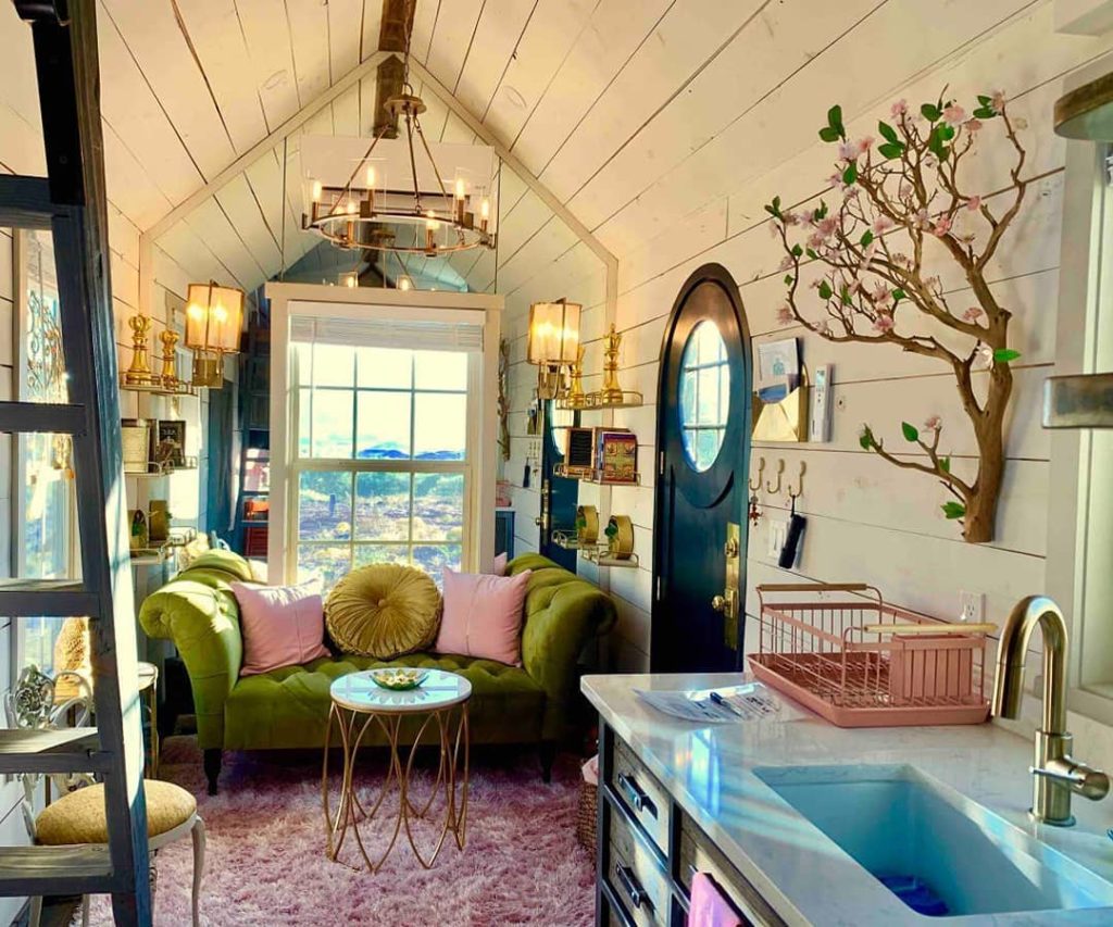 A tiny house with hanging light fixtures and a tree wall decoration. Photo via Instagram user @tnylvng