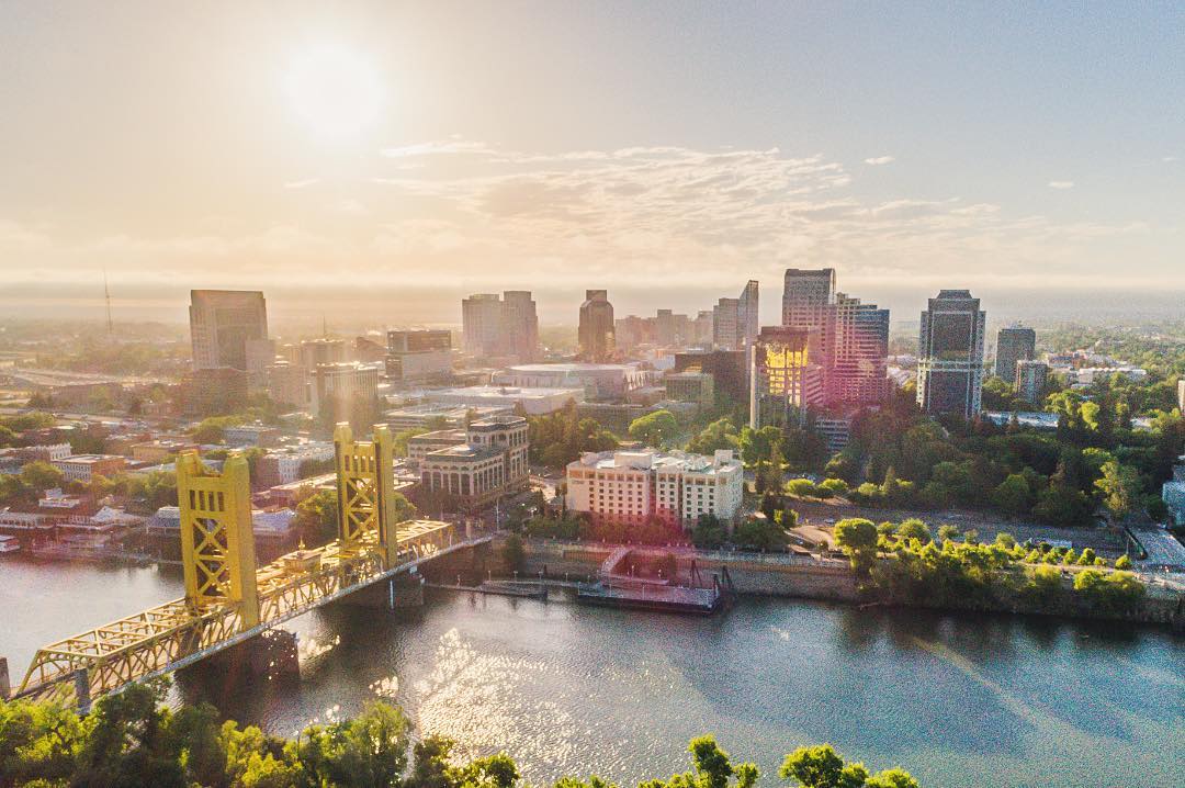 Aerial view of buildings and bridge in Downtown Sacramento. Photo by Instagram user @aerialsacramento