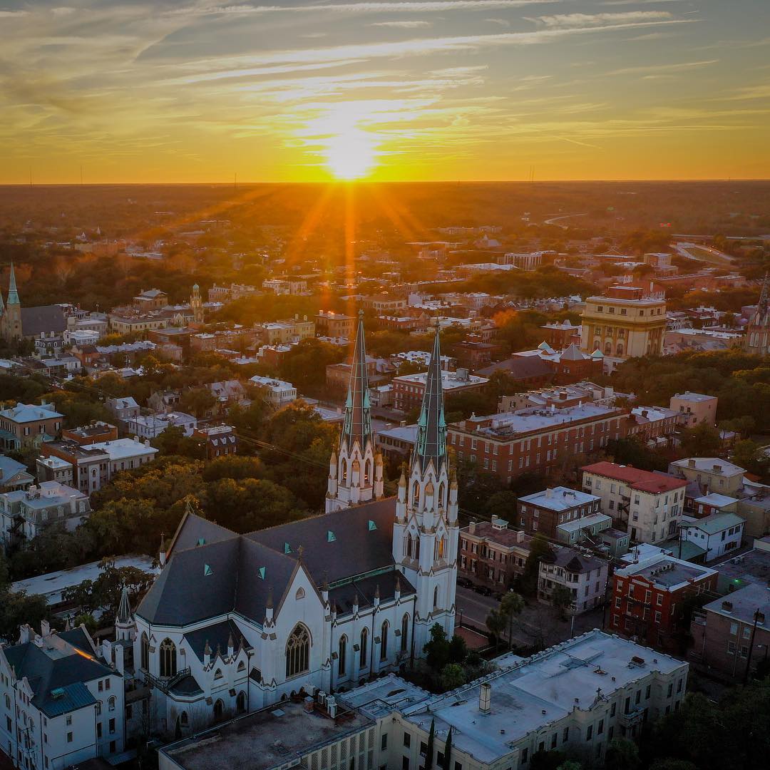 Sunrise over church and buildings in Savannah. Photo by Instagram user @riverrat_productions