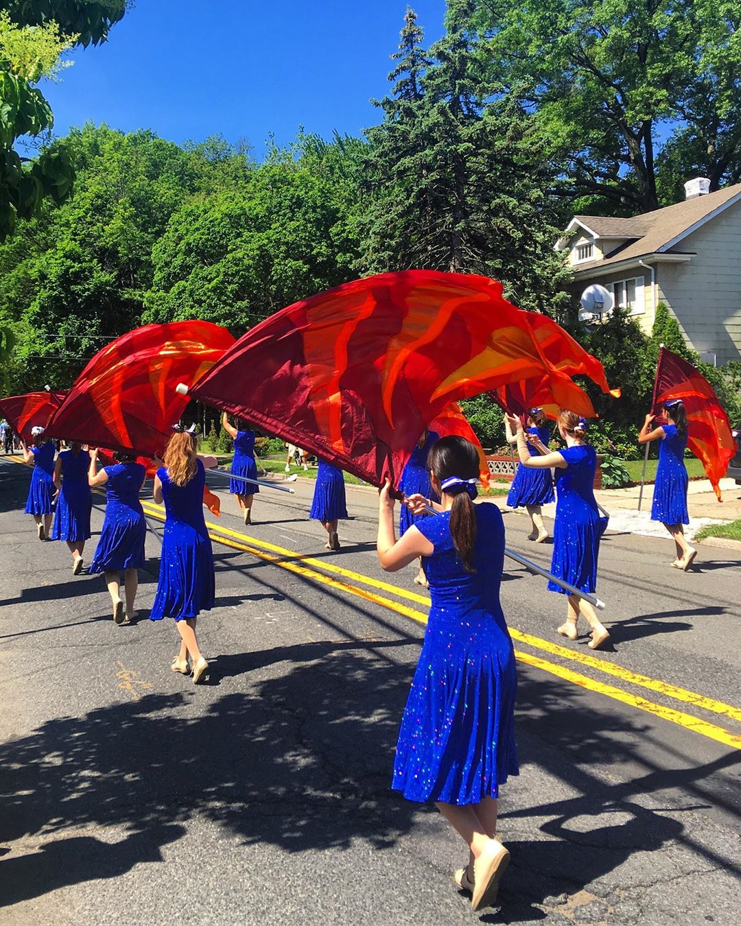 Girls waving red flags in parade. Photo by Instagram user @cap_one60