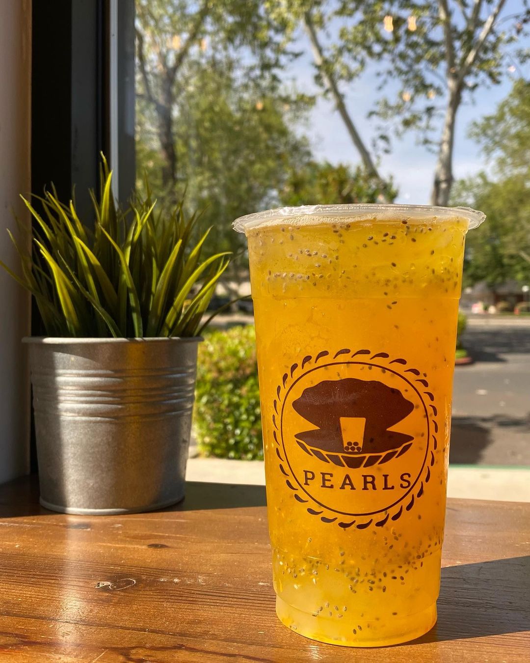 A tall cup of boba tea by Pearls on a table. Photo by Instagram user @sacpearls.