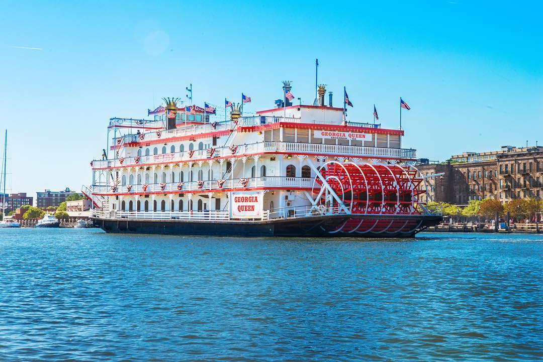 Red and white riverboat on the water. Photo by Instagram user @savannahriverboat
