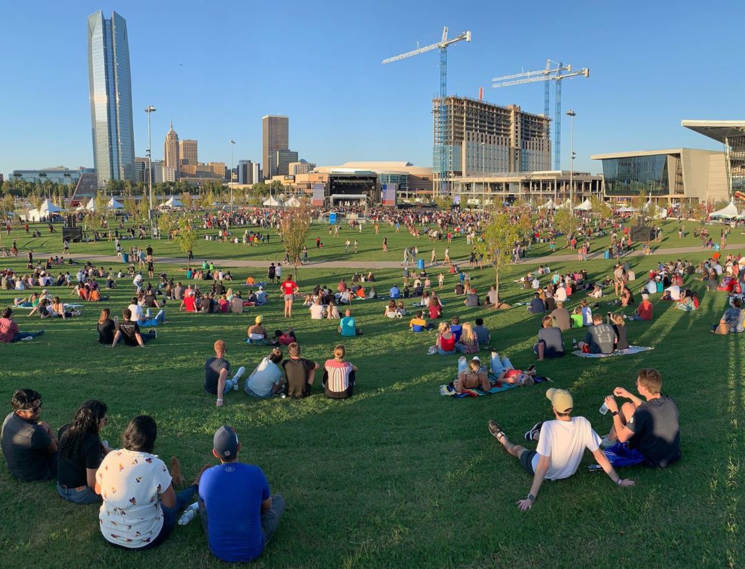 People sitting in a park listening to music. Photo by Instagram user @scissortailpark