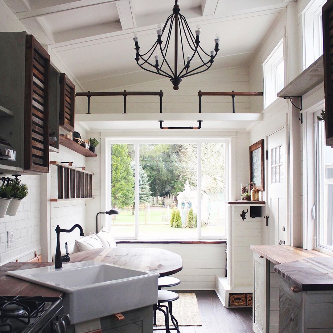 Tiny home kitchen with white walls and green cabinets. Photo by Instagram user @handcraftedmovement