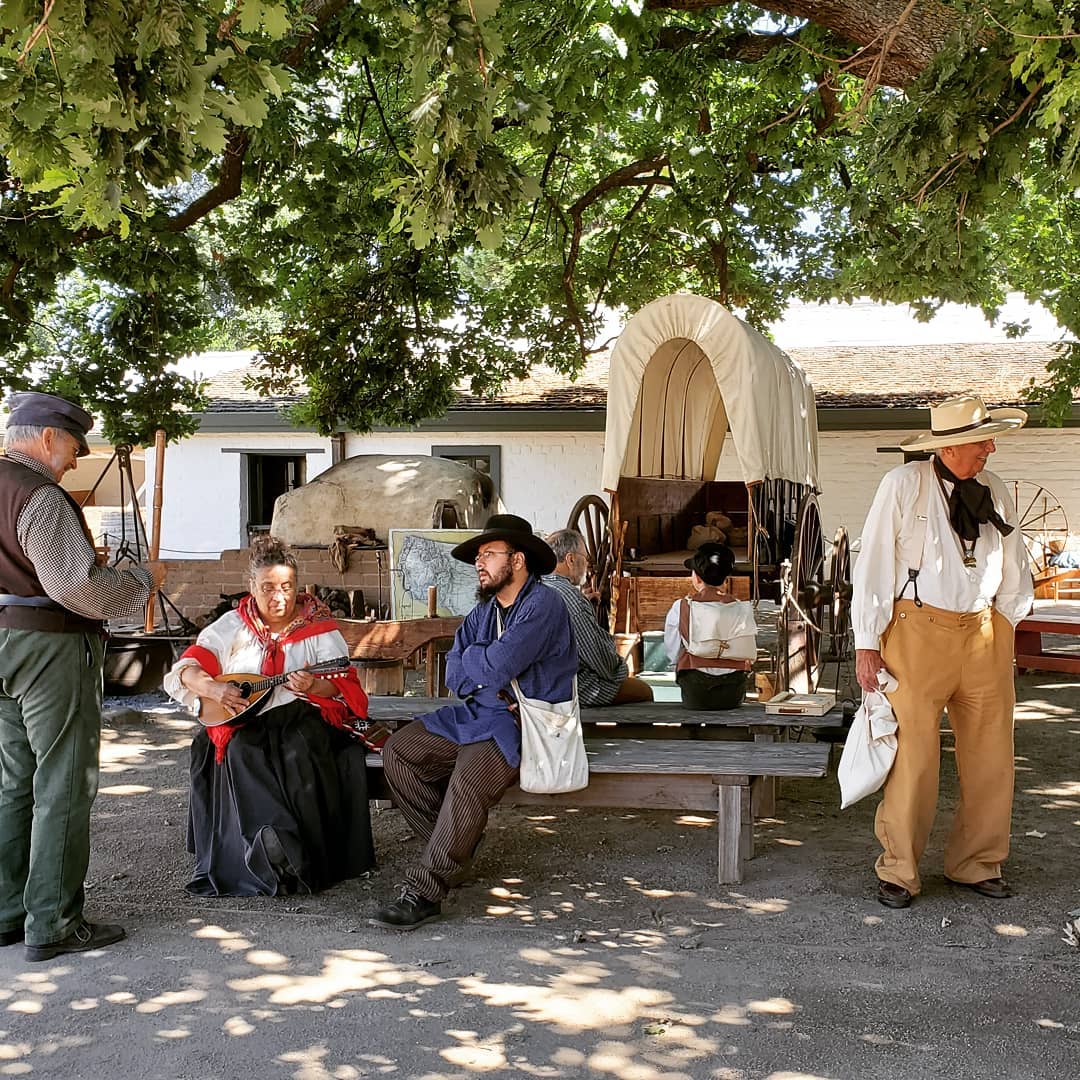 People in pioneer clothes playing instruments. Photo by Instagram user @suttersfortstatehistoric