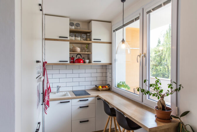 Tiny home kitchen with white wall and white cabinets.