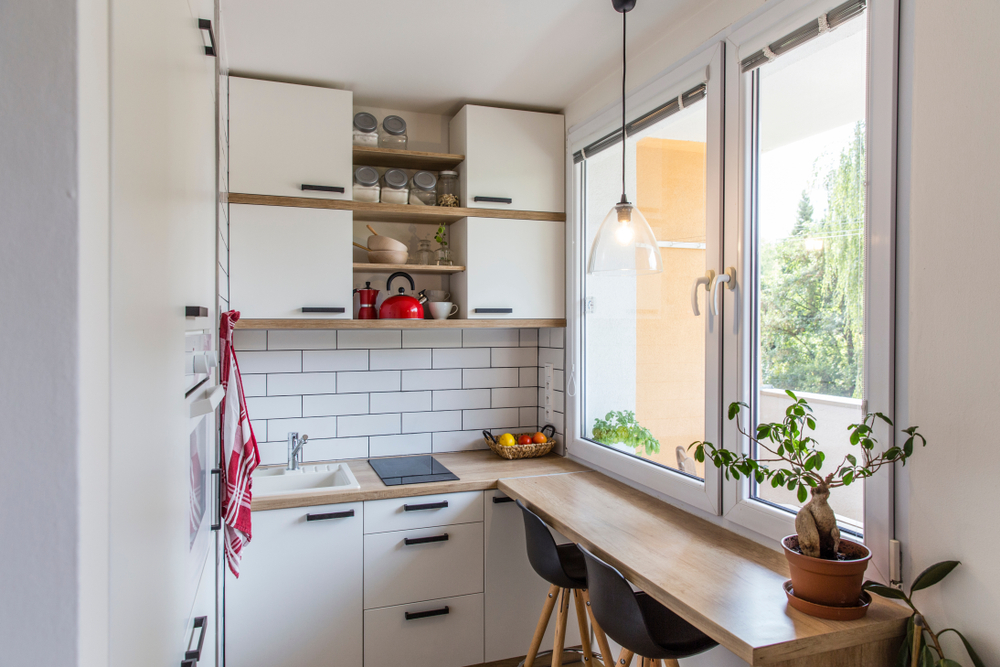 Tiny home kitchen with white wall and white cabinets.