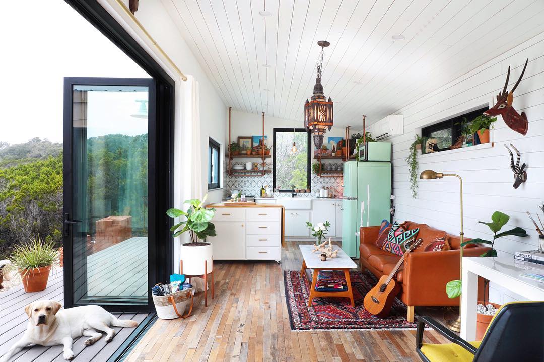 Tiny home with white and open window dog sitting on floor. Photo by Instagram user @kimlewisdesigns