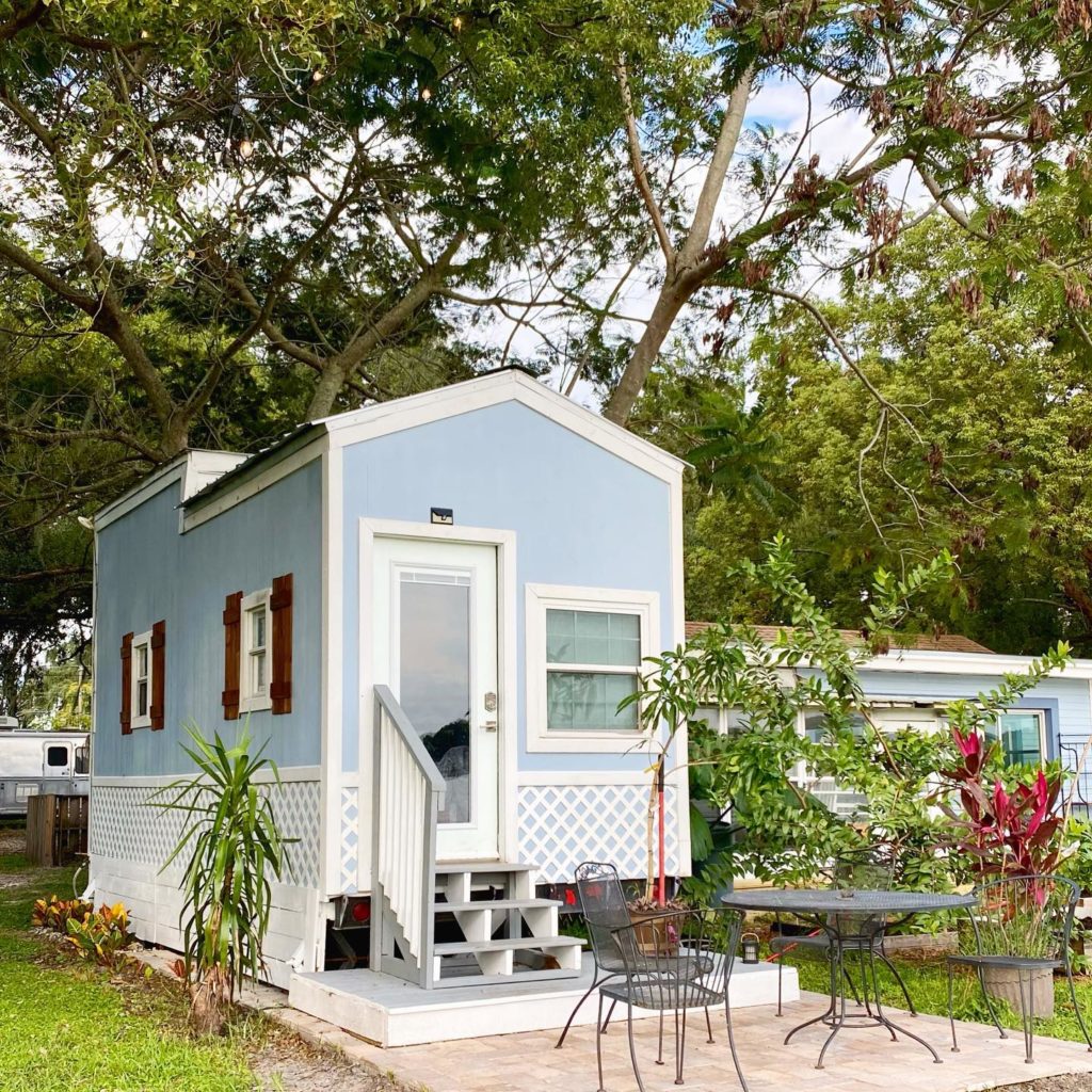 light blue tiny house with patio table and chairs photo via @tiny_house_orlando