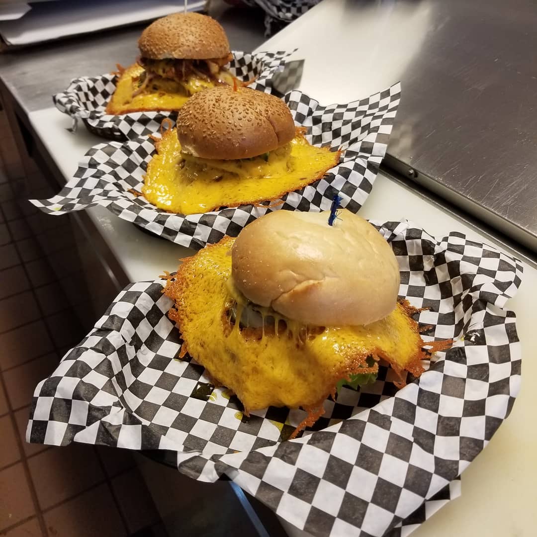 Three burgers covered in cheese. Photo by Instagram user @squeezeburgermidtown