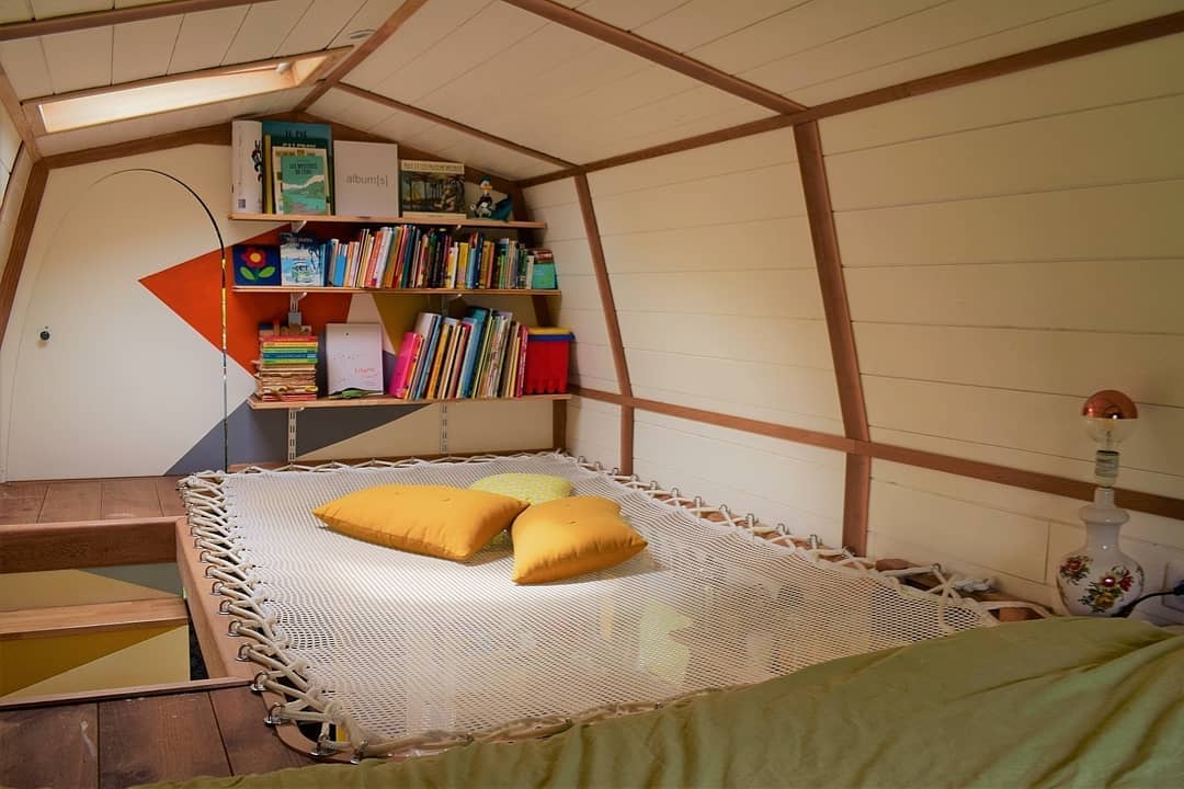 Tiny home loft we mesh floor and bookshelves. Photo by Instagram user @tinyhousekusku