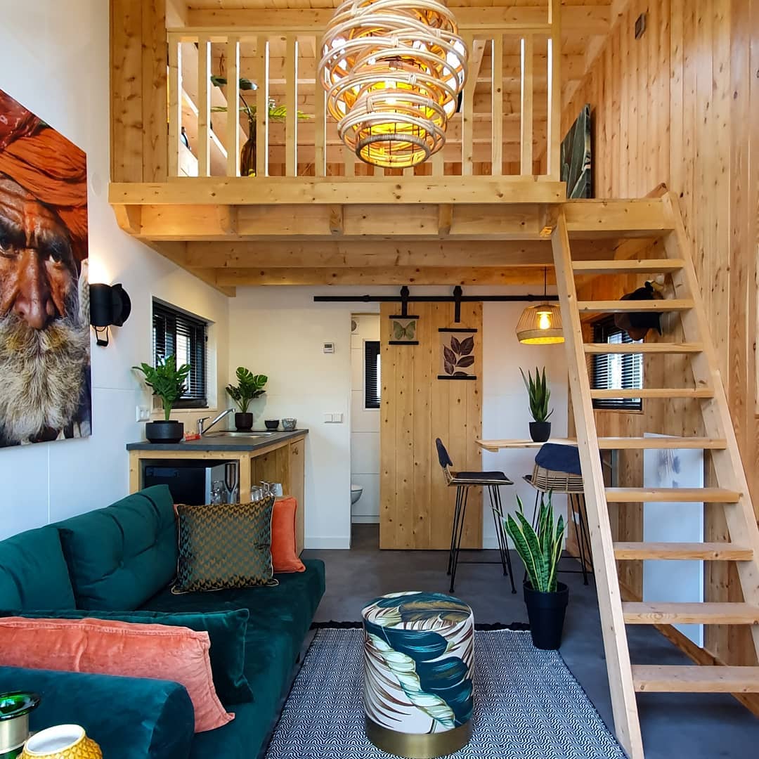 Tiny home with wood loft and green decor. Photo by Instagram user @tinyhousesdroomparken