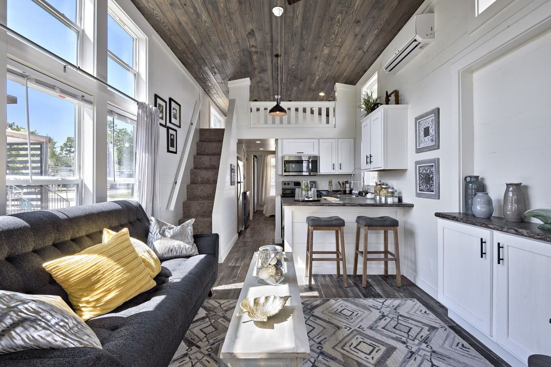 Pequeña casa con paredes blancas y decoración en gris.  Foto del usuario de Instagram @villagefarmaustin