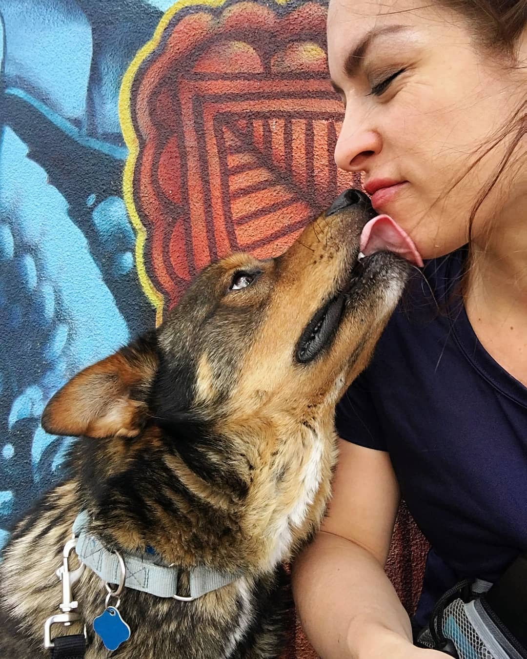 Dog licking woman's face. Photo by Instagram user @venuskelly