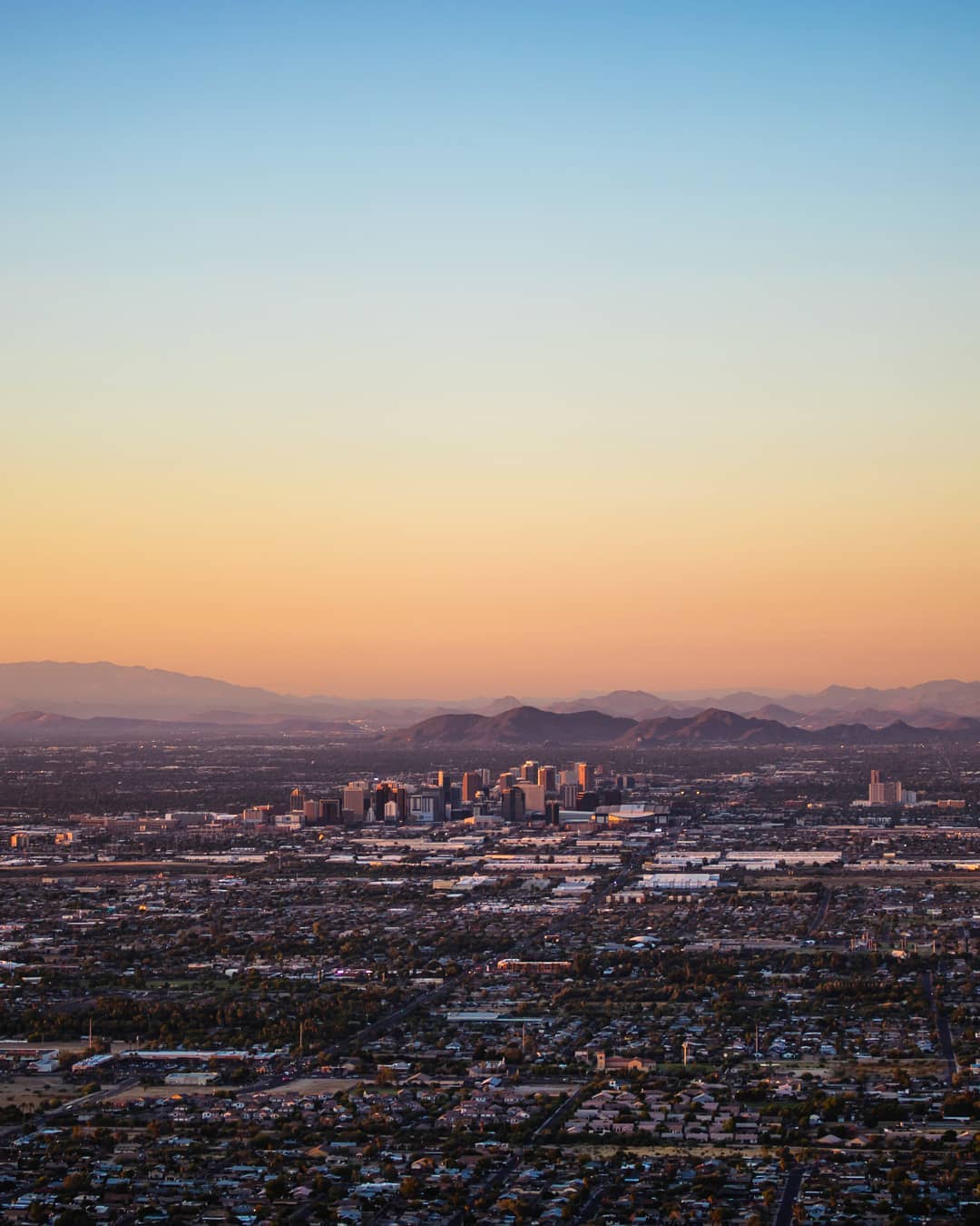 Skyline of mountains and buildings in Phoenix, AZ. Photo by Instagram user @maverick_shots