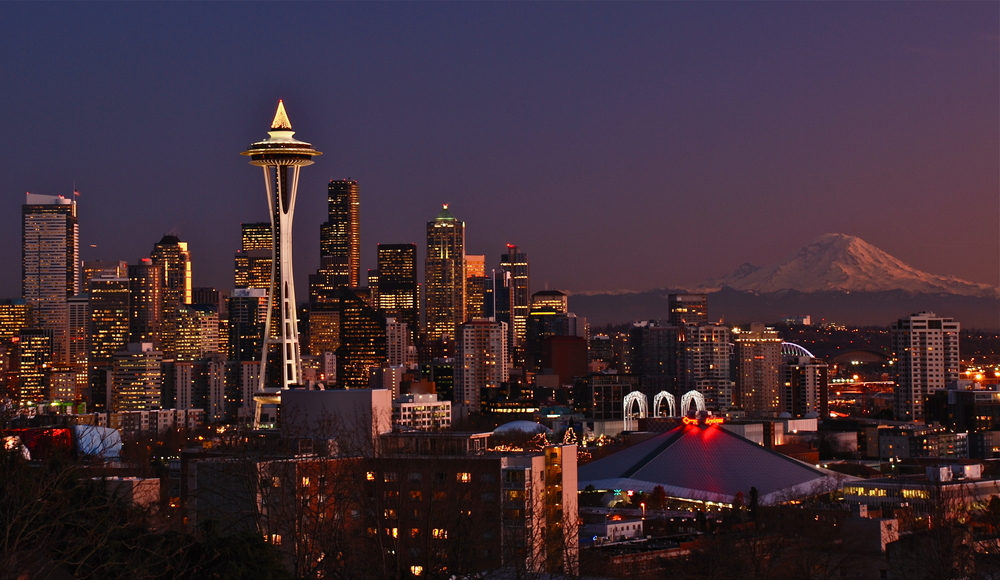 Skyline of tall buildings and Space Needle in Seattle at night.