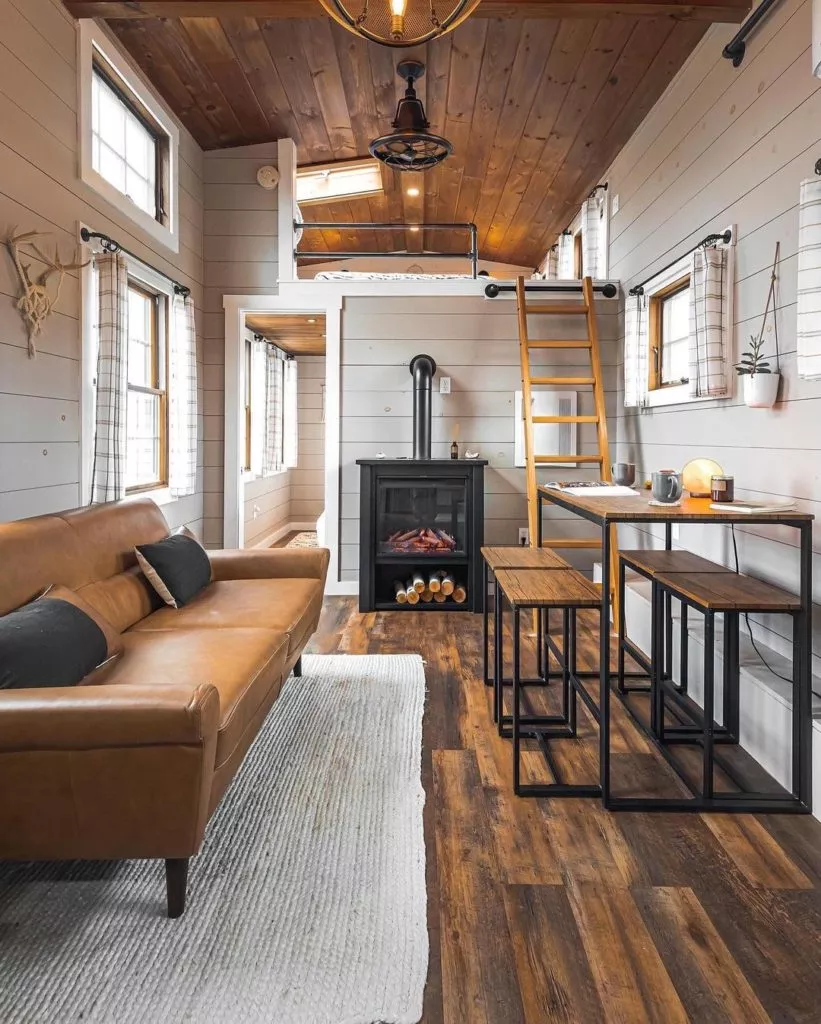 Rustic tiny house has a spacious interior and a balcony up top