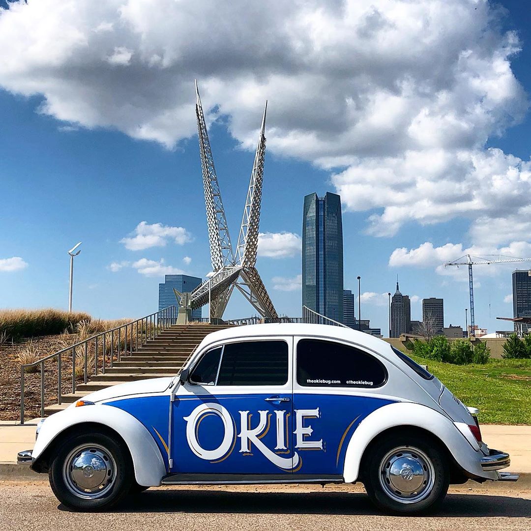 White and blue car parked outside in front of sculpture. Photo by Instagram user @theokiebug