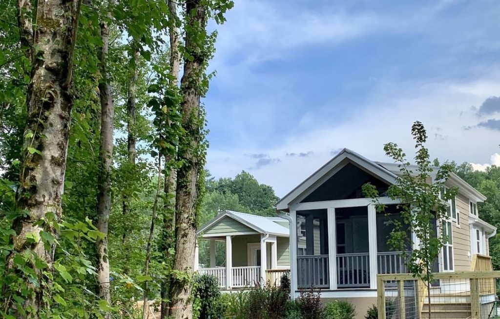 two grey tiny homes with trees photo via @simplelifecottages