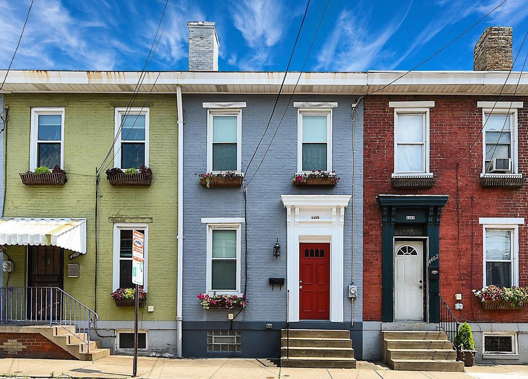 Green, Blue, and Red brick two-story row homes. Photo by Instagram user @alexisfatalsky