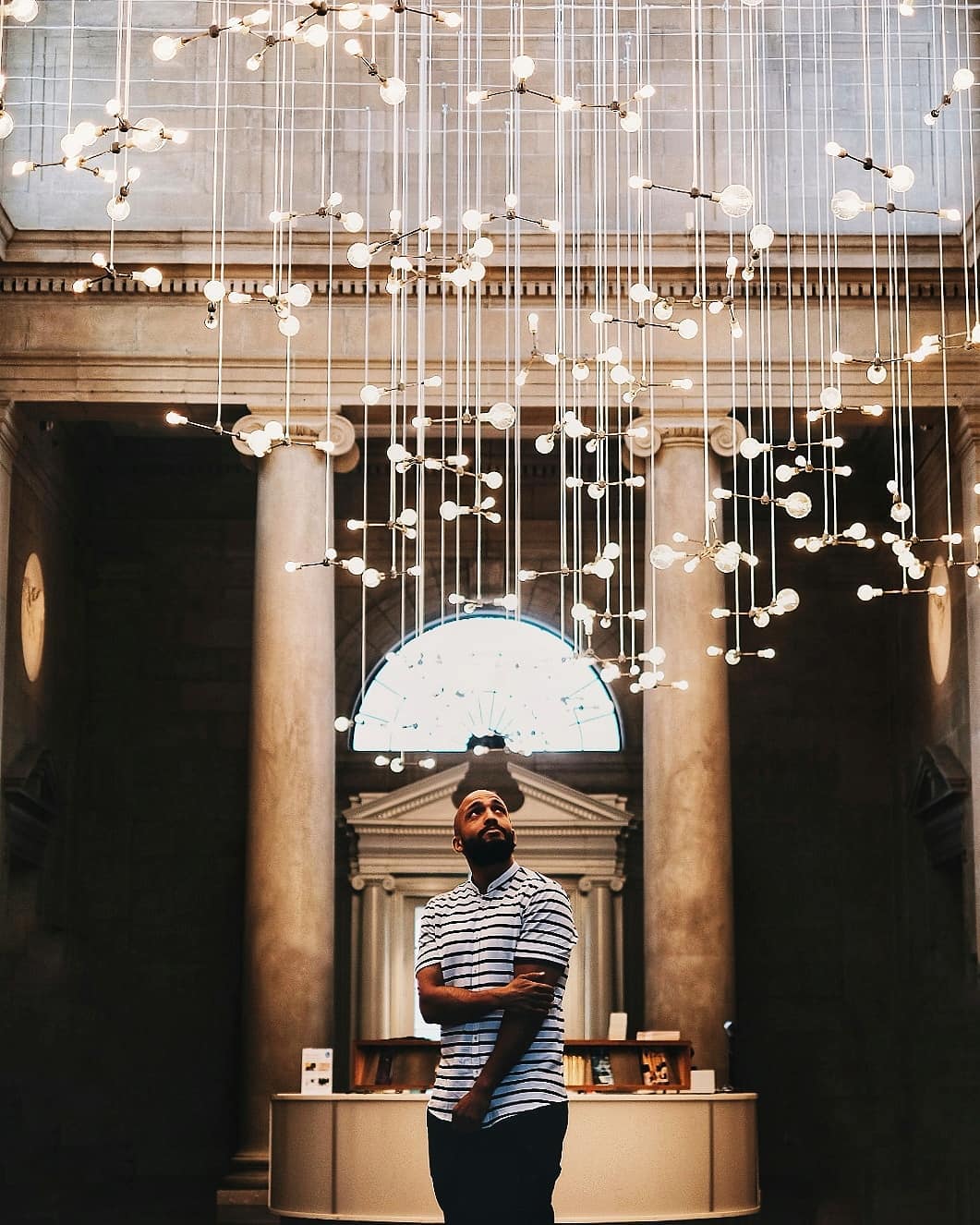 Guy standing under light art installation. Photo by Instagram user @jeffreytime_