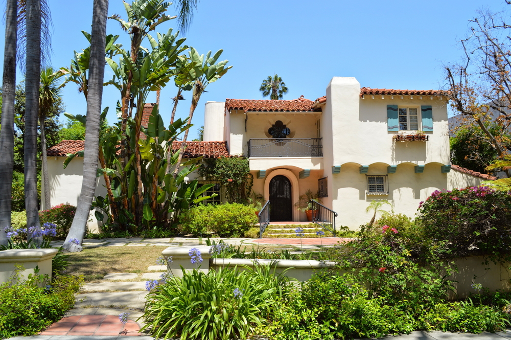 Los Angeles stucco home with brick pavilion and gardens in front yard